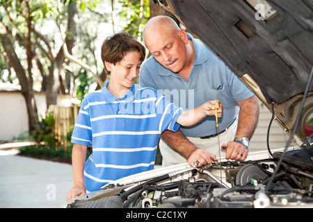 Père et fils travaillent sur la voiture ensemble. Le fils est de contrôler l'huile. Banque D'Images