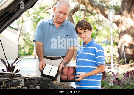 Père et fils, changement du filtre à air dans la voiture familiale. Banque D'Images