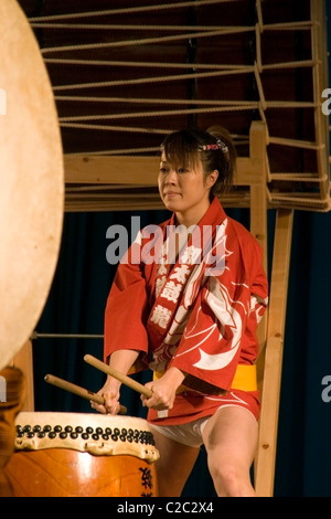 Une femme japonaise handicapés malentendants (sourds) joue un tambour taiko au Laos communiste. Banque D'Images