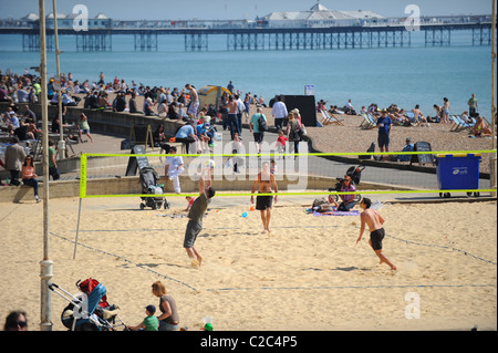 Un panier-Brighton Beach que le Royaume-Uni bénéficie de conditions météorologiques exceptionnellement bonnes pour la période de l'année jouer au volley-ball Banque D'Images