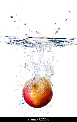 Red Apple les projections dans l'eau isolé sur fond blanc Banque D'Images