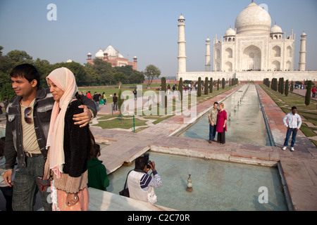 Deux visiteurs étrangers posent pour une photo en face du Taj Mahal à Agra, en Inde. Banque D'Images