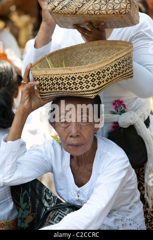 Bali, Indonésie. femme âgée dans les vêtements avec un don aux dieux s'assoit Banque D'Images