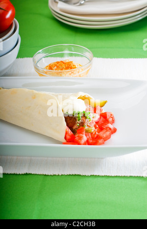 Falafel traditionnelle frais emballage sur le pain pita avec des tomates fraîches hachées Banque D'Images