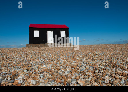 L'ondulé rouge et noir, avec des portes blanches construit sur la plage de galets à Rye Harbour. East Sussex SE ANGLETERRE Banque D'Images