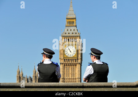 Deux officiers de soutien de la communauté de police métropolitaine avec Big Ben Beyond lors d'un ciel bleu de printemps à Westminster Londres Angleterre Royaume-Uni Banque D'Images