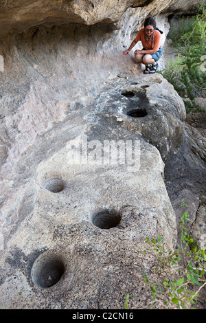 Femme avec Roche préhistoriques les trous de mortier à Cuevas Amarillas abri rocheux Big Bend Ranch State Park New York USA Banque D'Images