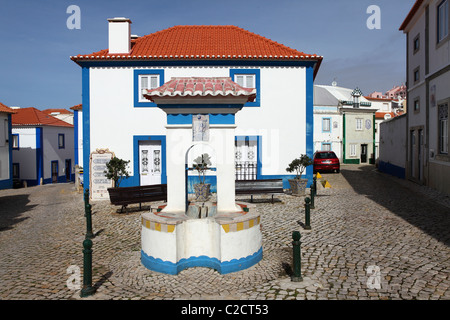 Un puits, devant une maison aux murs blanchis à la chaux dans une rue pavée de la ville de Ericeira surf, près de Lisbonne, Portugal. Banque D'Images