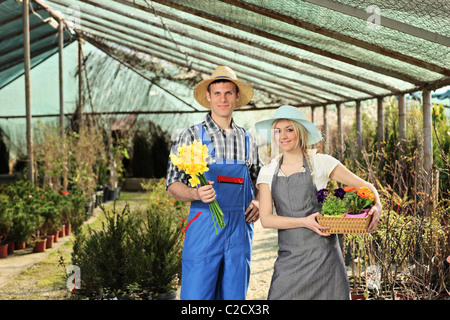 Jardiniers, hommes et femmes tenant des pots dans un jardin Banque D'Images