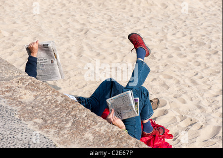 Les gens lire et se détendre sur la plage, St Ives, Cornwall, United Kingdom Banque D'Images