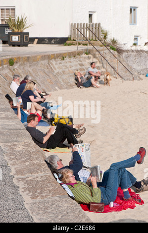 Les gens lire et se détendre sur la plage, St Ives, Cornwall, United Kingdom Banque D'Images