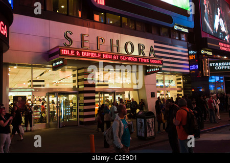 Vue nocturne de l'entrée du magasin Sephora à Times Square à Manhattan, New York City, avec des enseignes lumineuses au néon et une foule de gens. Banque D'Images