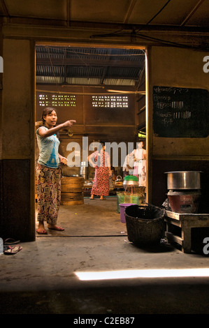 Pyay, Birmanie, Myanmar - Juillet 2010 : Le Restaurant Manager donne aux tâches domestiques pour la serveuse du kit Banque D'Images