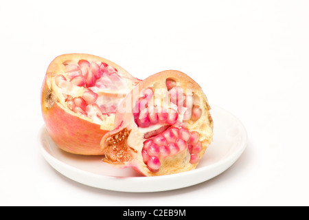 Close-up de grenadier (Punica granatum) moitiés sur fond blanc Banque D'Images