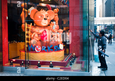 Nettoyage de la fenêtre l'homme Build-A-Bear Workshop, à la Cinquième Avenue, Manhattan, New York City, USA Banque D'Images