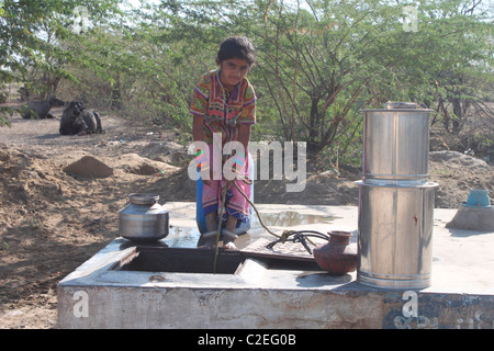 Une jeune Indienne à la collecte de l'eau d'un puits couvert dans le Gujarat, Inde Banque D'Images
