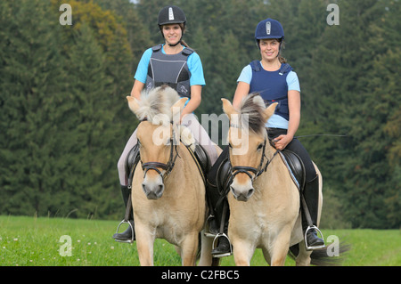 Deux fille portant un body protector équitation sur dos de cheval norvégien Banque D'Images