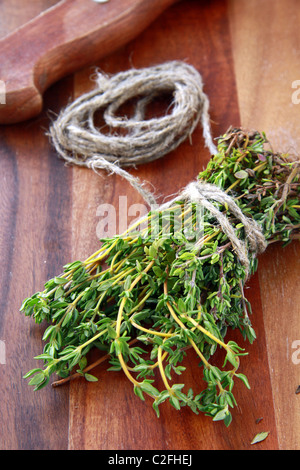 Bouquet de thym frais et un couteau sur une planche en bois Banque D'Images