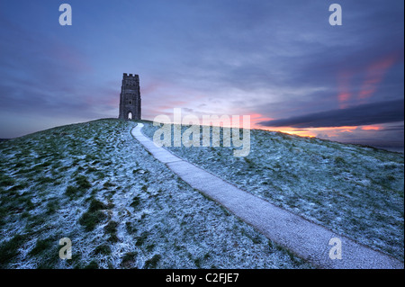 St Michael's tower au sommet de Glastonbury Tor sur un hiver froid comme le soleil du matin par des nuages épais Banque D'Images