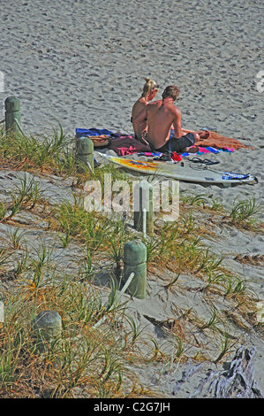 Couple sitting on beach, Mount Maunganui, Tauranga, Bay of Plenty, North Island, New Zealand Banque D'Images