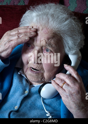 La démence âgée mémoire vieille dame 96 ans inquiet lutte pour se souvenir de mémoriser à la maison parle anxieusement sur son téléphone Banque D'Images