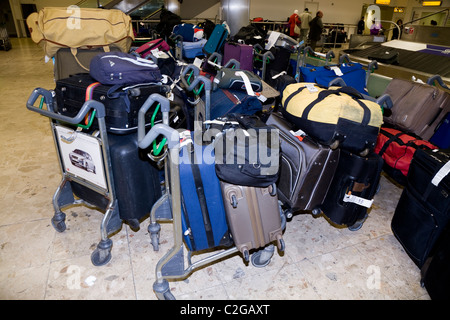 Arriéré / retour log / accumulation / retard / entassés / stack / bagages empilés à Londres Heathrow LHR aéroport International. UK. Banque D'Images