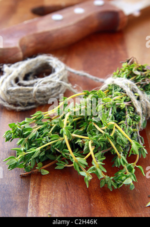 Bouquet de thym frais et un couteau sur une planche en bois Banque D'Images