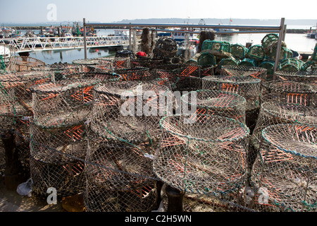 Les bateaux de pêche Le port de Poole avec pots de pêche au crabe en premier plan. Banque D'Images