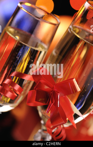 Deux wineglasses avec un champagne sur fond d'étincelles multicolores Banque D'Images