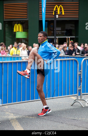 Haile Gebrselassie s'échauffe avant le Manchester 10k 2010 en face d'un restaurant Mcdonald's Banque D'Images