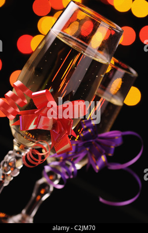 Deux wineglasses avec un champagne sur fond d'étincelles multicolores Banque D'Images