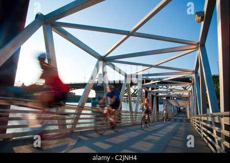 Les cyclistes sur la Vera Katz Eastbank Esplanade passerelle sur la rivière Willamette, avec vue sur le pont de Burnside, Portland, Oregon, USA Banque D'Images