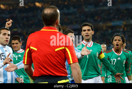 Le Mexique et l'Argentine les joueurs affronter arbitre assistant Stefano Ayroldi après une controverse Argentine but à la Coupe du Monde 2010. Banque D'Images
