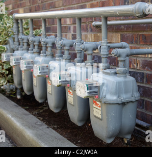 Rangée de compteurs de gaz gris à un complexe d'appartements avec des rampes compliquées Banque D'Images