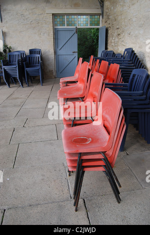 Des piles de chaises rouges et bleus au Princess Pavilions, Falmouth, Cornwall Banque D'Images