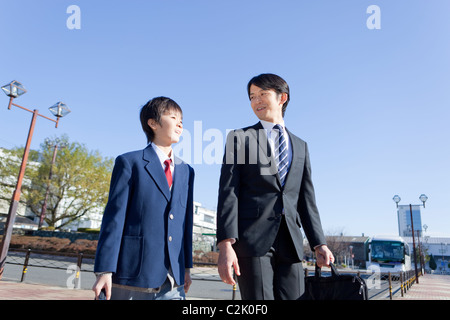Père et Junior High School Boy Walking Banque D'Images