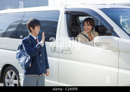 Junior High School Boy parler à mère dans une voiture Banque D'Images