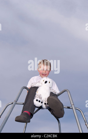 Un modèle a publié la photo d'un garçon de sept ans et sa peluche à l'extérieur sur une escalade au Royaume-Uni Banque D'Images