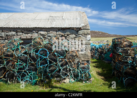 Des casiers à homard empilés à côté d'un cabanon sur l'île de Tory, comté de Donegal, Irlande. Banque D'Images