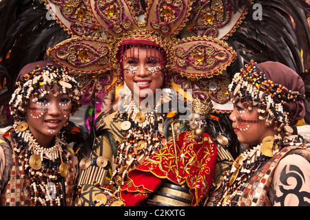 Trois dames en costumes tribal en perles tête robes avec un Sto. Nino du prince. Banque D'Images