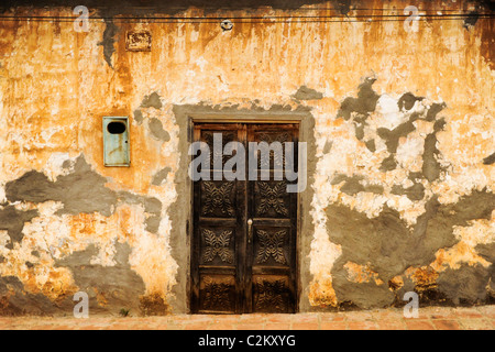 Une porte dans une rue avec du plâtre de travailler avec orange couleur gris dans la pittoresque ville coloniale de Barichara, Colombie Banque D'Images