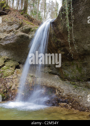 Cascade en train de tomber sur falaise creux dans les bois longs temps d'exposition Banque D'Images