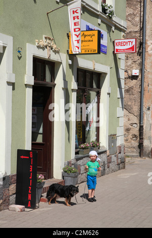 Kid avec chien en face de shop dans mall kowary ancienne ville allemande schmiedeberg. Pologne, la basse Silésie, Europe Banque D'Images