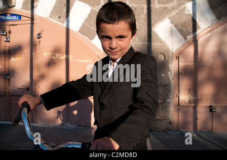 Un portrait d'un jeune garçon kurde avec son vélo dans le vieux quartier de la ville de Diyarbakir dans la région orientale de l'Anatolie, dans le sud-est de la Turquie. Banque D'Images