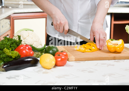 Belle femme prépare la nourriture dans la cuisine Banque D'Images