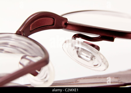 Une paire de lunettes de vue pliée sur un fond blanc Banque D'Images