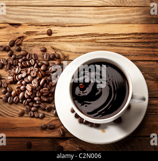 Goutte tomber dans une tasse de café. On a wooden background Banque D'Images