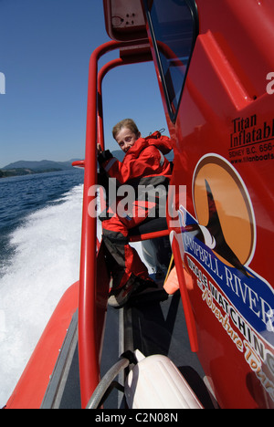 Garçon sur le zodiaque à pleine vitesse pendant l'observation des baleines voyage, Campbell River, Vancouver Island, Canada Banque D'Images