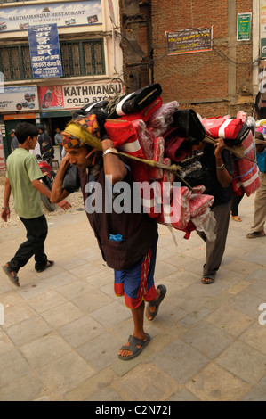 Manoeuvre sherpa portant de lourdes charge , la vie , les Népalais à Katmandou , rue de Katmandou au Népal , vie Banque D'Images
