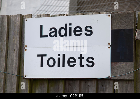 Des toilettes dames signe sur clôture en bois dans la région de park Banque D'Images